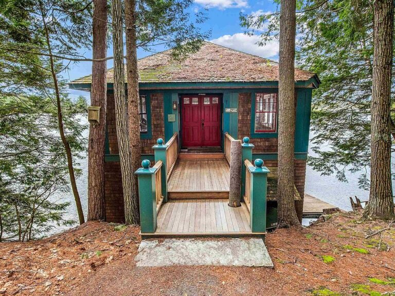 Love the boathouse! Pretty lakefront setting! C. 1974 in New Hampshire. $390,000 cut!